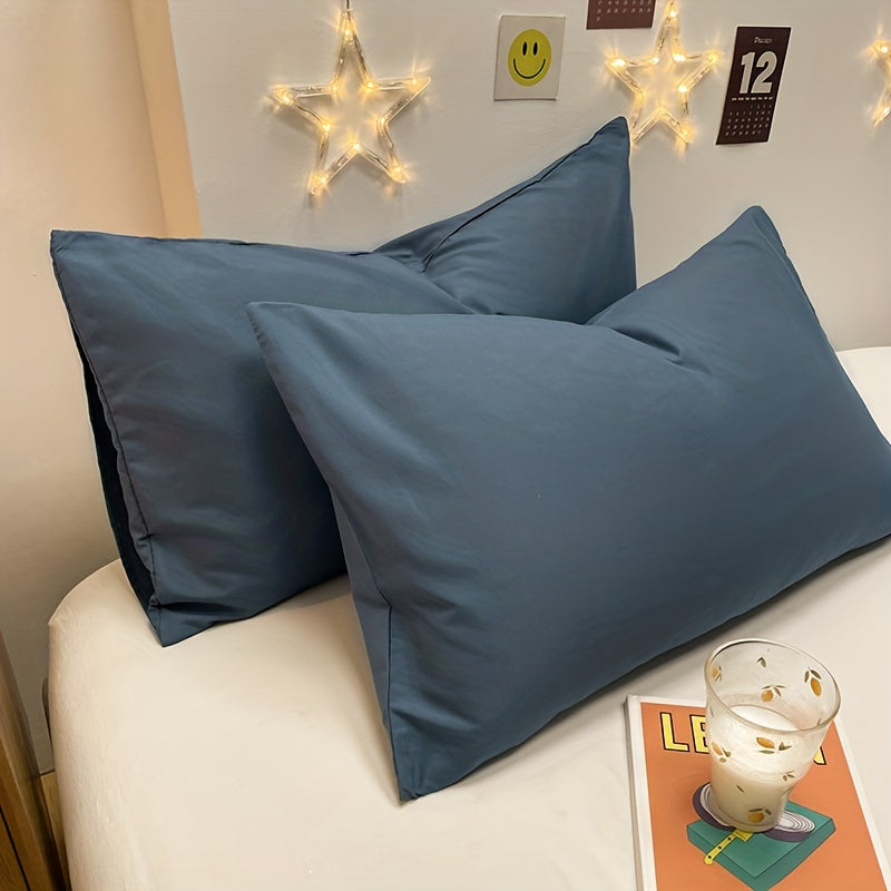 Two polyester pillowcases for bedroom use, featuring a multi-colored solid design.