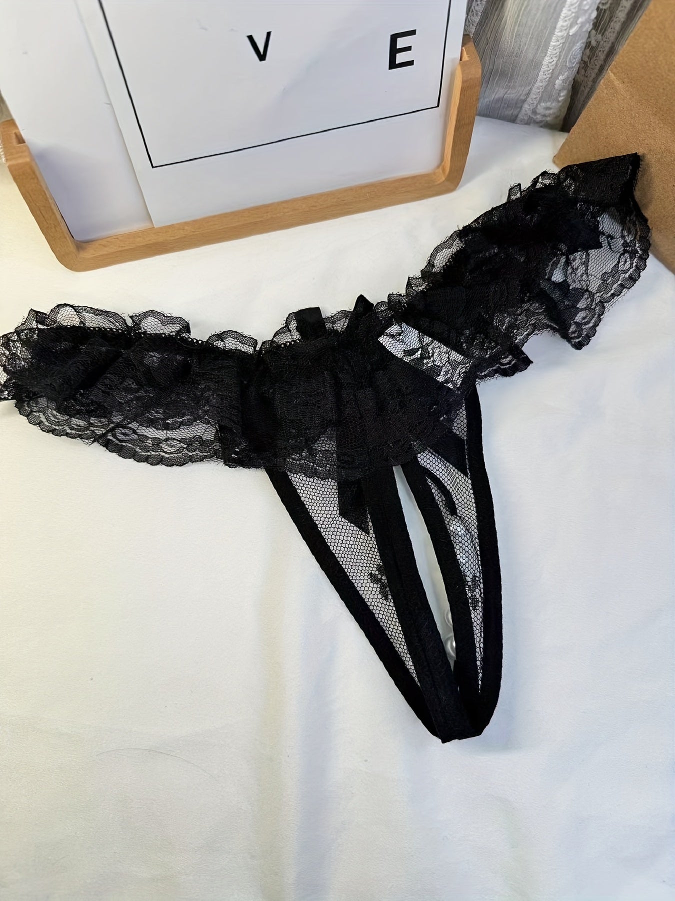 Double-bow, sexy, transparent, hot, lace crotchless thong with pearl massage detail.