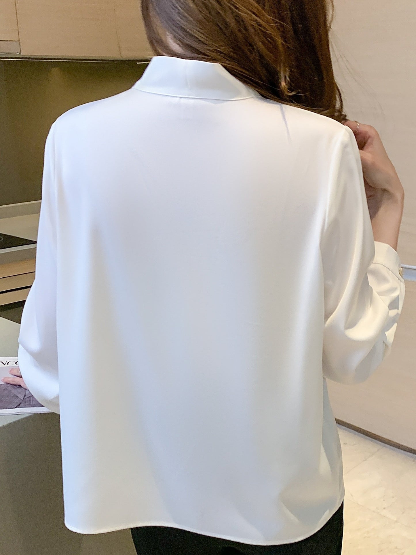 Slimming white chiffon blouse with tie-neck design, perfect for work or casual wear.