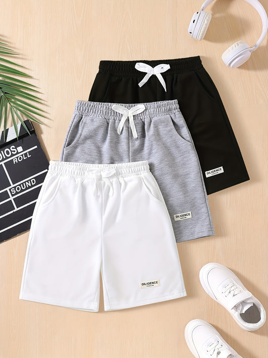 Three-pack of boys' summer shorts in solid colors, made from polyester knit with slight stretch, featuring elastic drawstring waist and regular fit. Ideal for sports and leisure activities