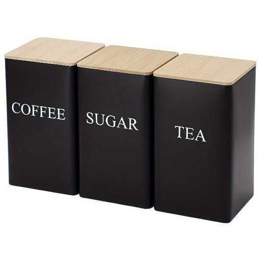 Three square metal canisters with wooden lids - one for tea, one for sugar, and one for coffee.