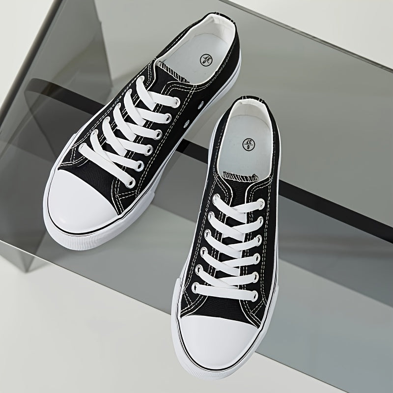 Black and white low top lace-up sneakers for women with rubber sole, fabric lining, and durable outsole for all-day comfort. Casual footwear with sleek design and fabric upper.