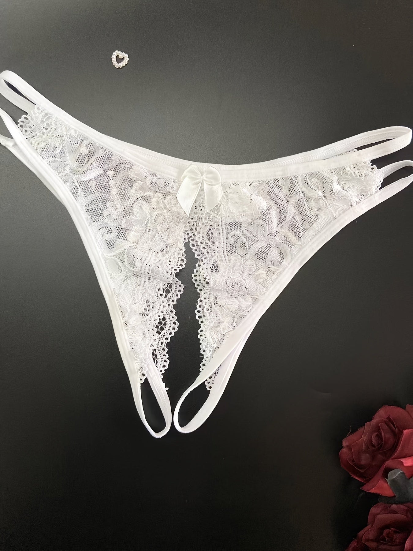 Open crotch lace thong panties with bow detail. Made of breathable polyester/spandex blend.