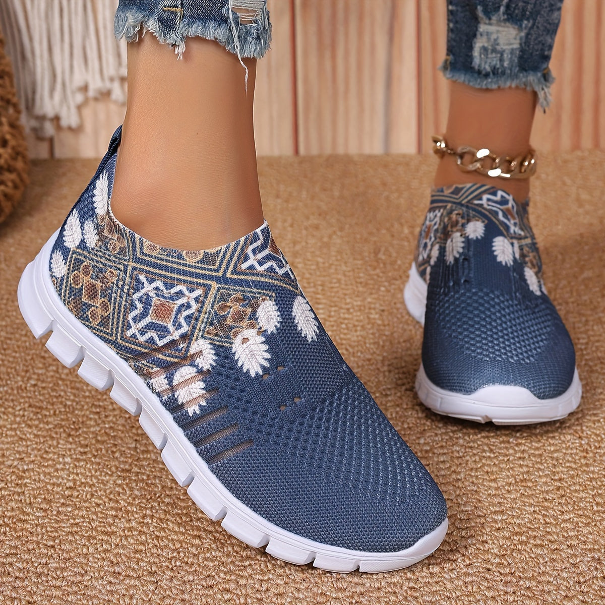 Women's casual slip-on sneakers in blue knit fabric with white floral and geometric patterns, featuring a lightweight EVA sole and breathable low-top design. Perfect for everyday wear with