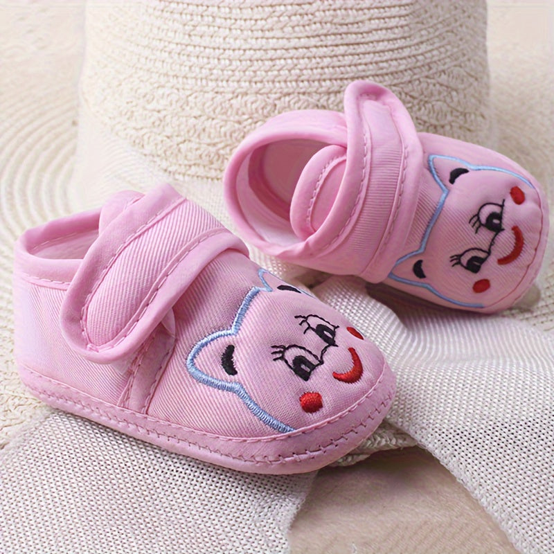 Cute baby walking shoes for boys and girls in light blue with cartoon faces, non-slip soles, and hook-and-loop closure. Ideal for first steps in any season.