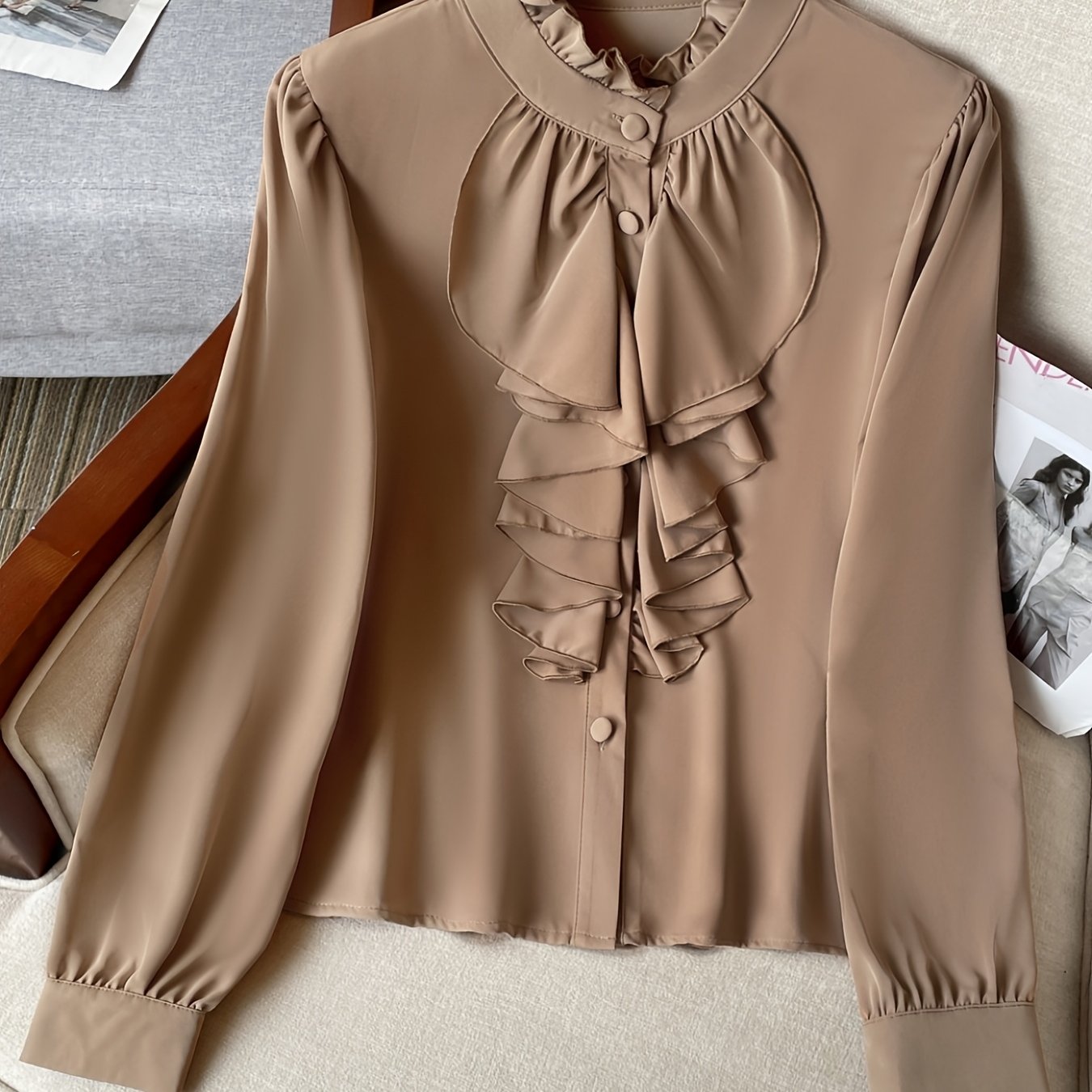 Stylish polyester blend blouse with ruffle detail, stand collar, and button front. Suitable for spring, summer, and fall.