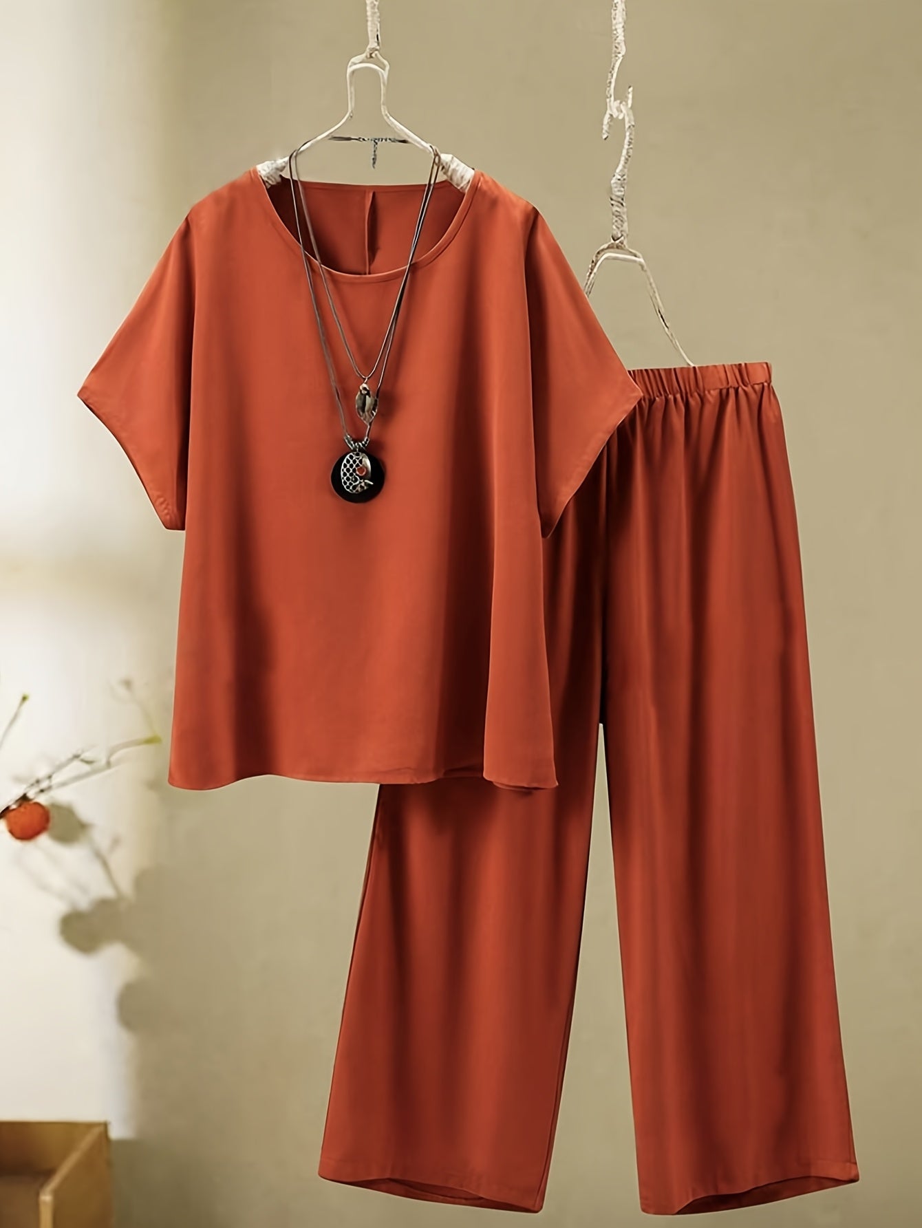 New plus-size vacation set includes round-neck short-sleeve top and long pants made from soft, sturdy fabric, perfect for women.