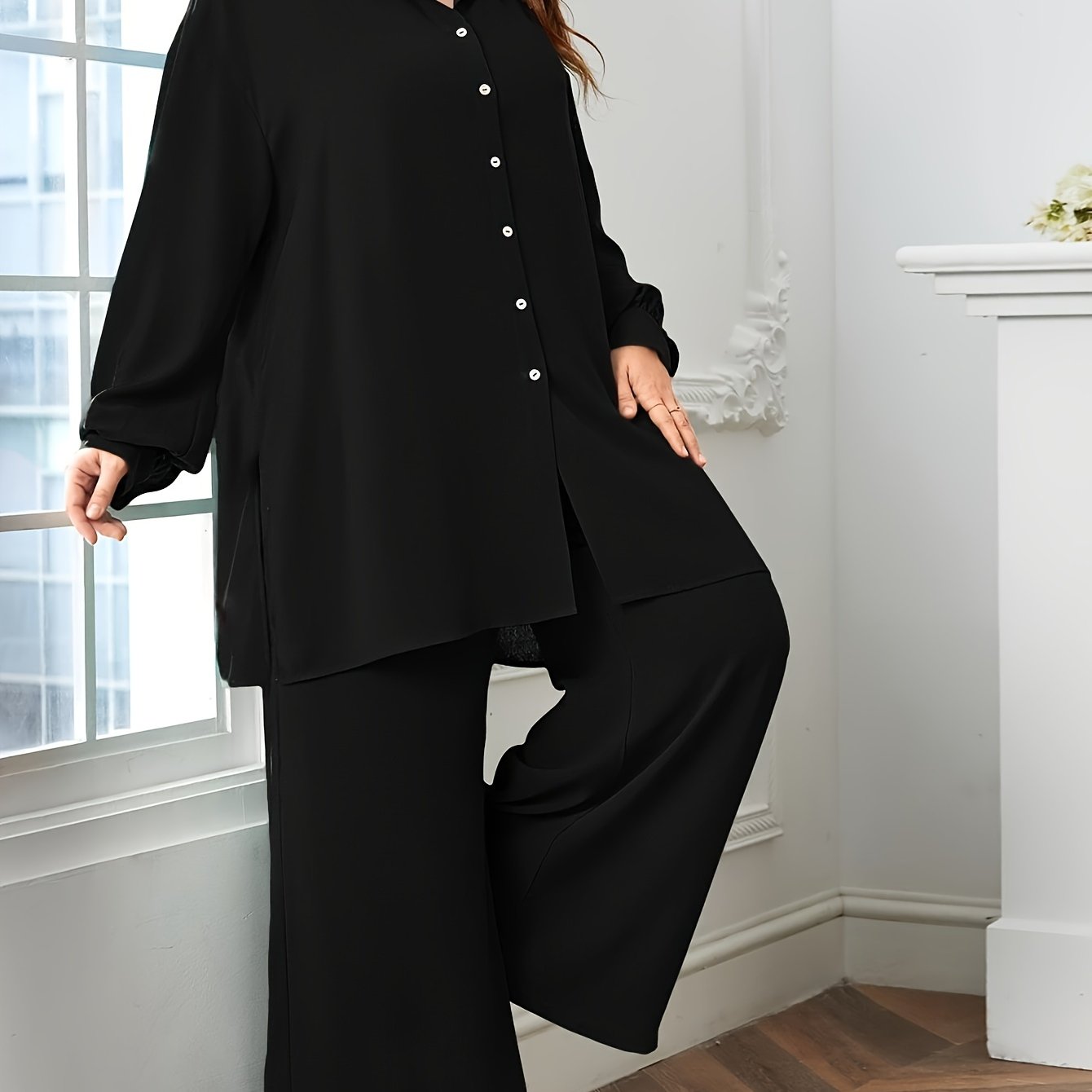 Black polyester blend pants with split details and a relaxed blouse comprise an elegant oversized V-neck two-piece set.