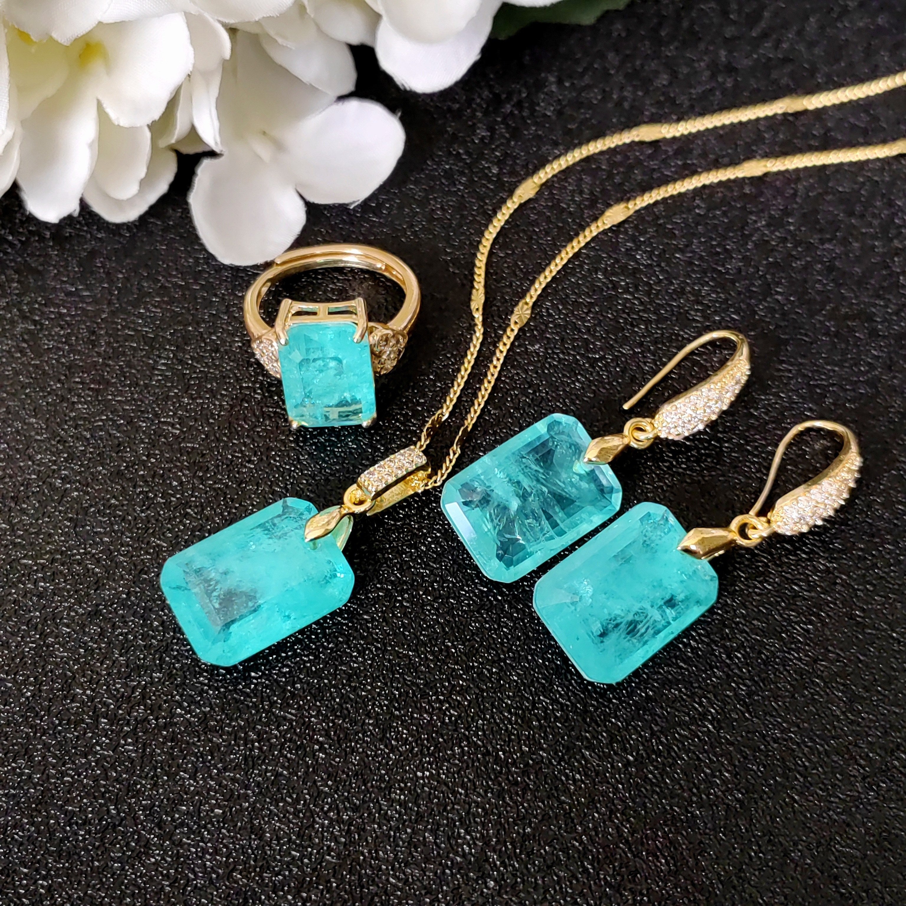 Upgrade your style with the MEETMAY Elegant Paraiba Blue Jewelry Set for Women - featuring a Charm Necklace, Earrings, and Ring adorned with Unique Textures. Ideal for both formal events and everyday wear.