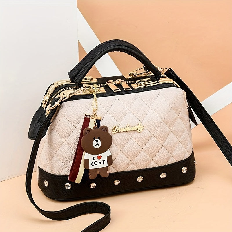 Stylish black shoulder bag for women with cute bear charm, detachable strap, zip closure, and quilted texture - ideal for travel and shopping.