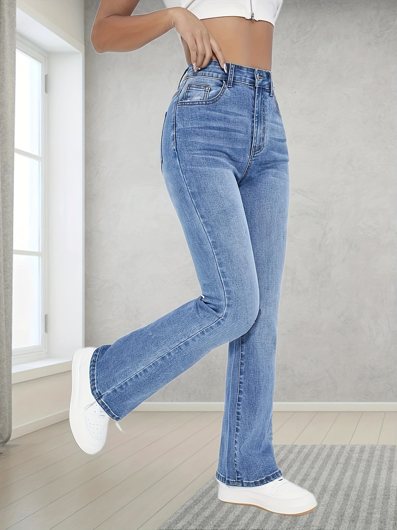 Washed blue flare leg jeans with stretch, slant pockets, and bell bottom design for women.