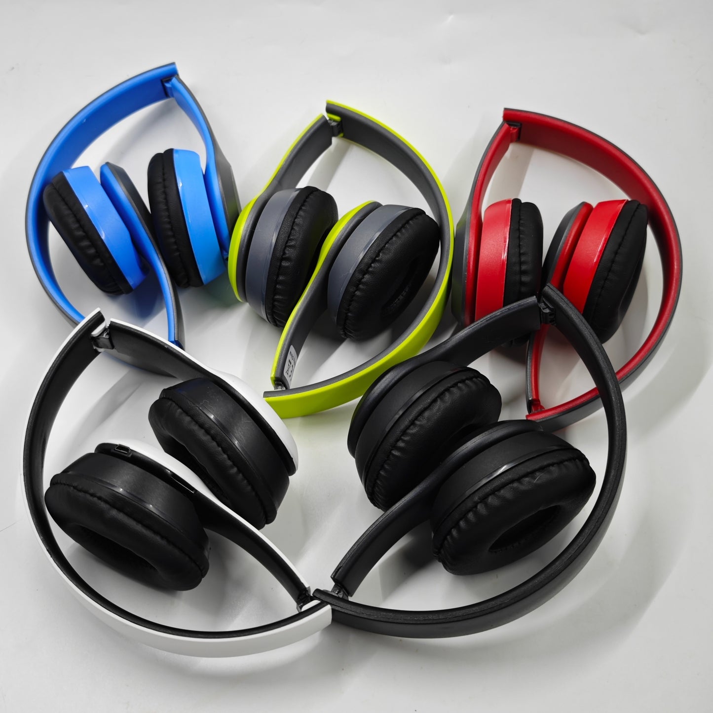 Wireless foldable headphones with hi-def sound, mic for gaming, rechargeable battery, adjustable headband, padded earcups, and available in multiple colors.