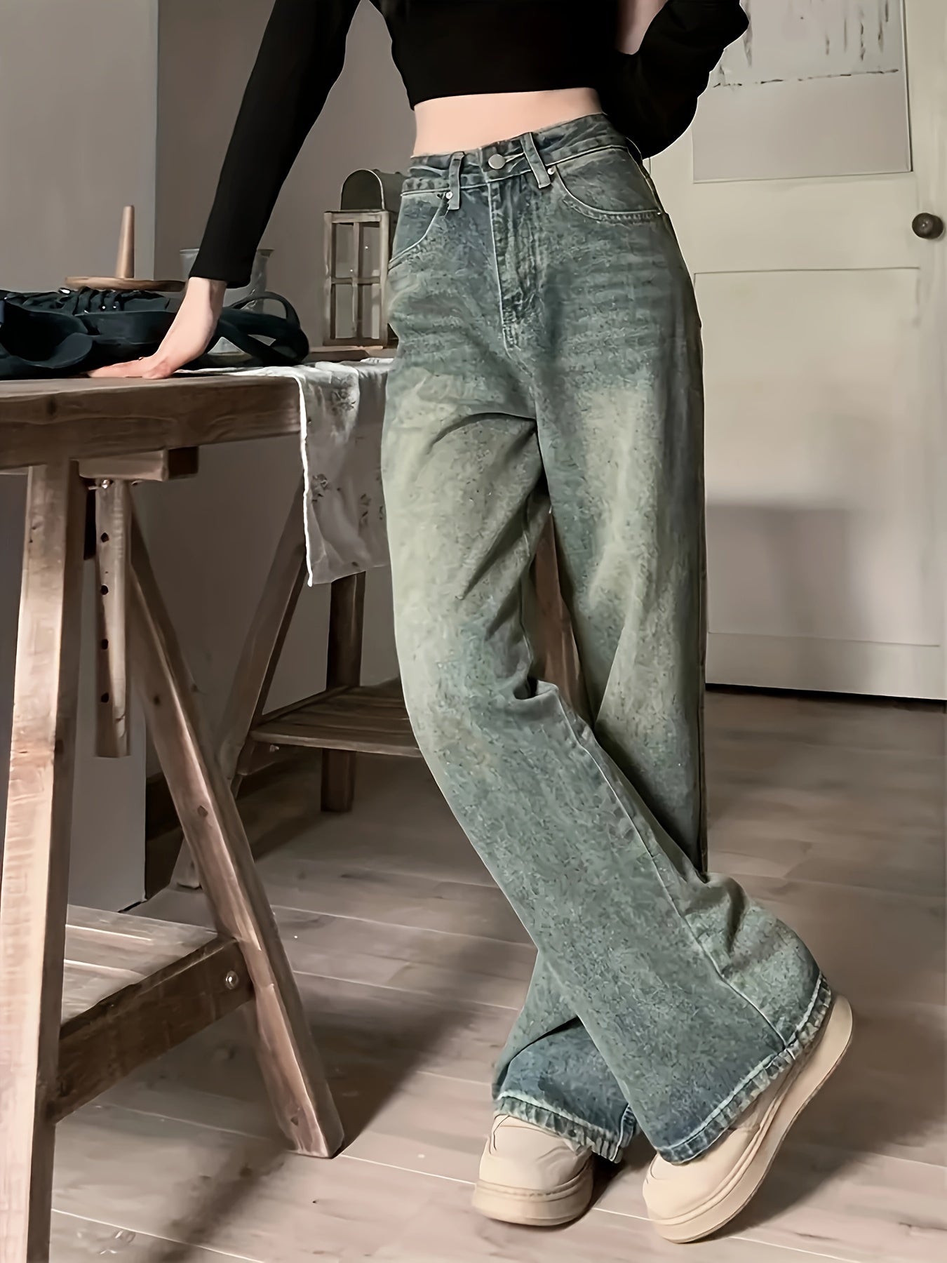 Women's distressed washed blue denim pants featuring a loose fit, whiskering, casual style, and zipper button closure.