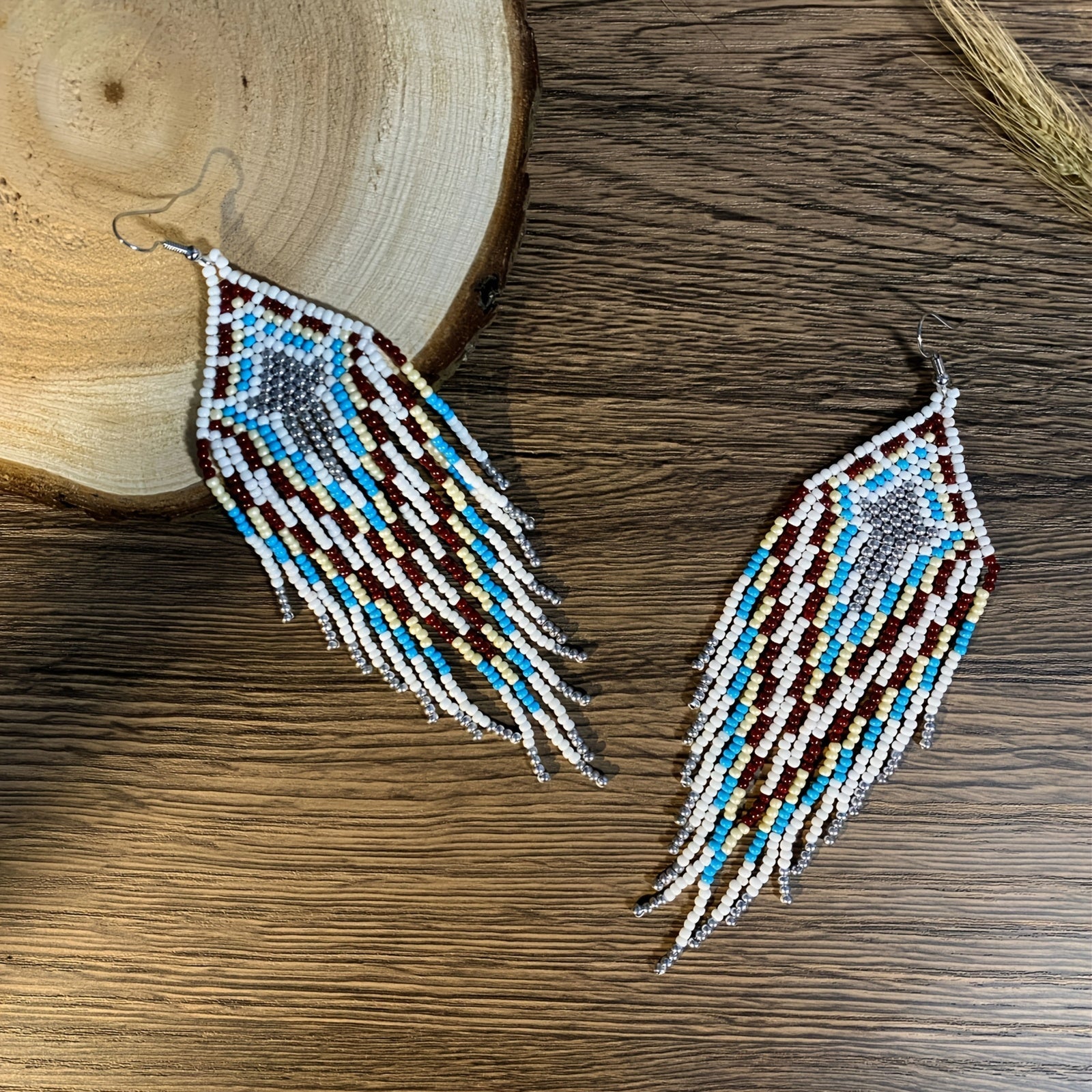 Vintage boho beaded earrings featuring a pair of blue multi-color charm beads in a classic geometric pattern. Handmade with long tassels and woven beads, these earrings exude elegance and sophistication, making them the perfect jewelry for women.