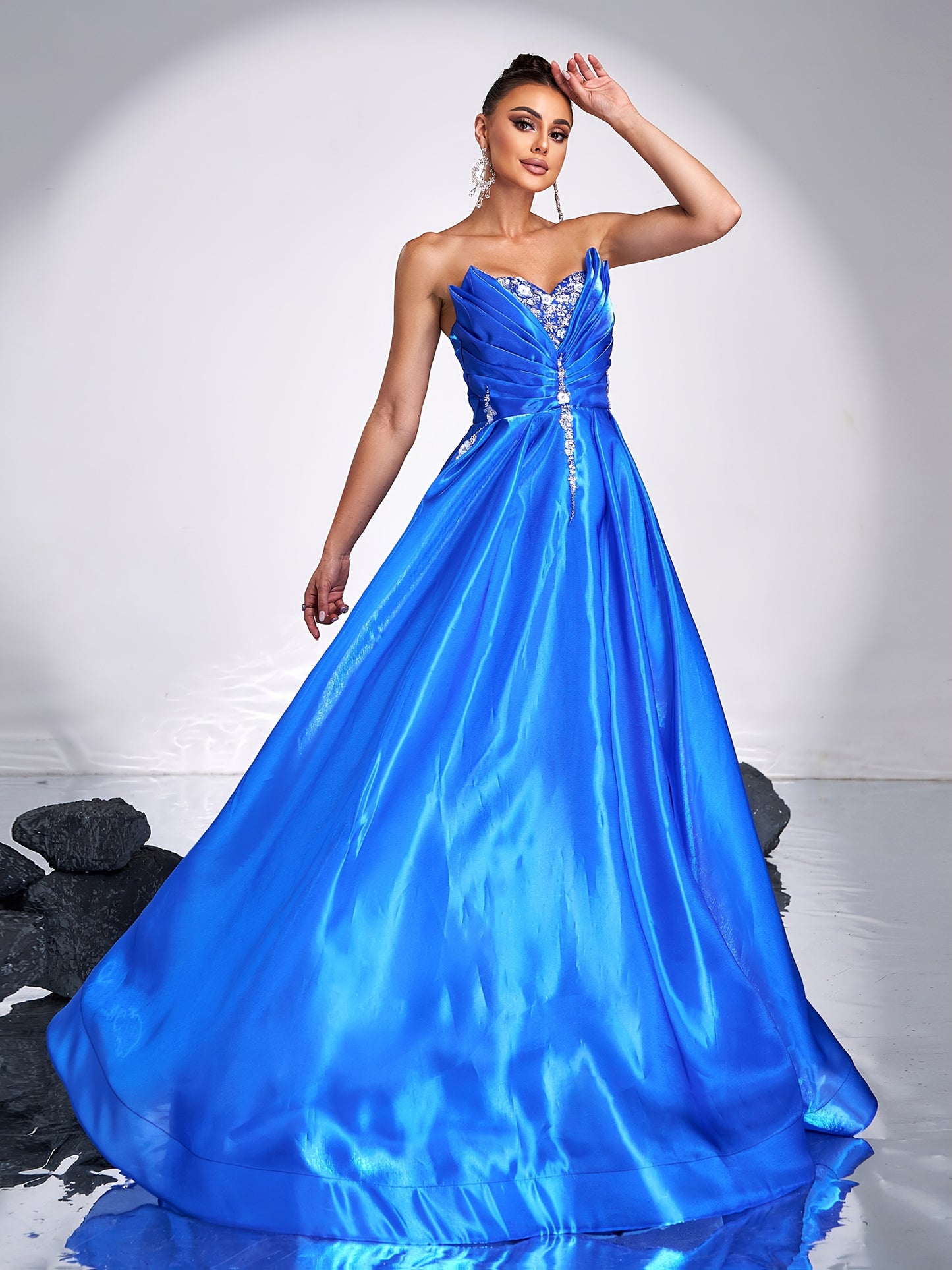 Elegant royal blue satin tube dress with rhinestone detailing and backless design, perfect for parties and formal events. Off-shoulder gown with flowing skirt and structured silhouette.