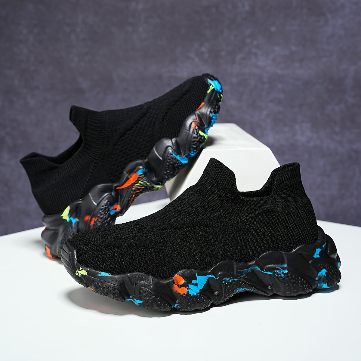 Breathable knit slip-on sneakers for kids in camo and black with comfy EVA sole for year-round wear.