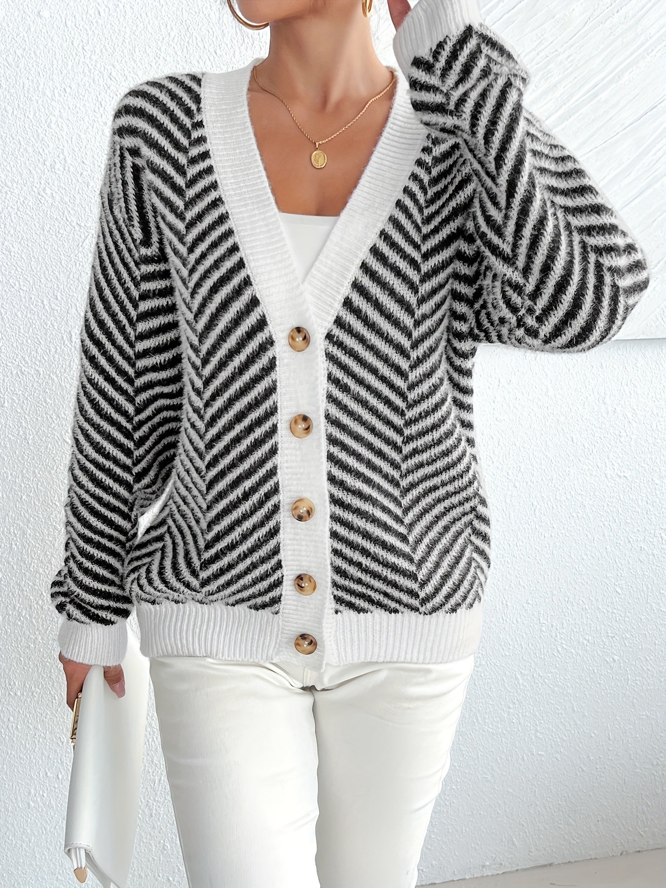 Stylish women's zebra stripe cardigan in black and white. Features button front, long sleeves, and V-neck. Made of a casual polyester blend for fall/winter. Perfect for trendy fall fashion.