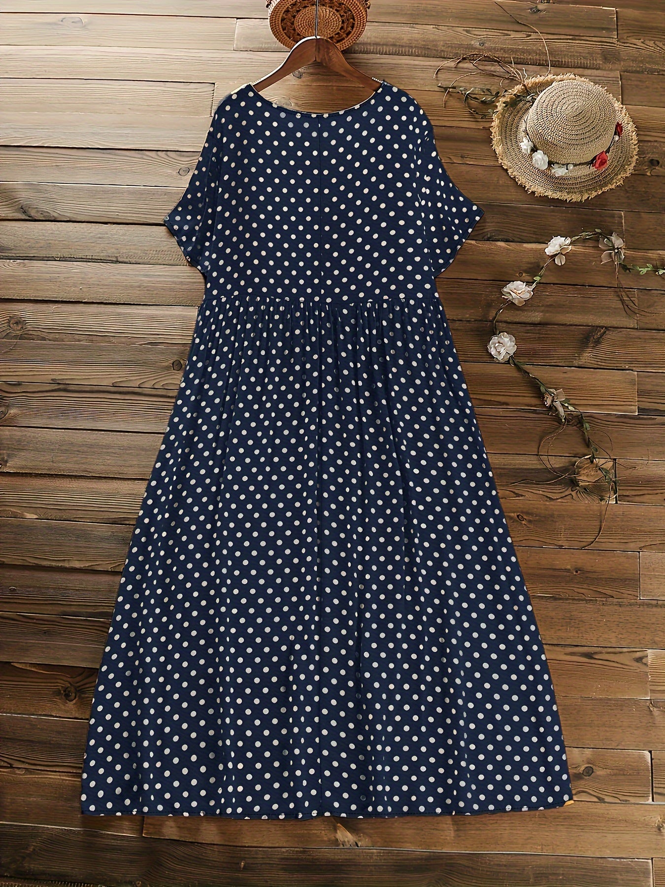 Machine washable navy blue midi dress with white polka dots, short sleeves, round neck, and ruffle detail.