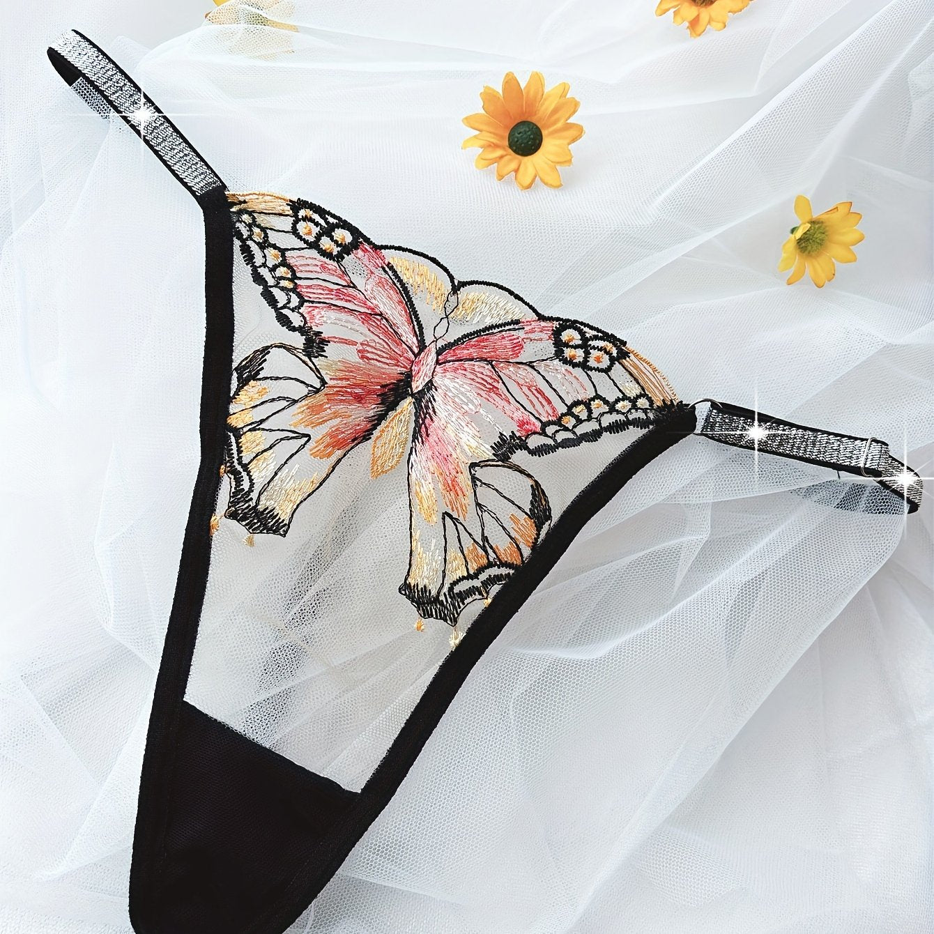 Hand-washable purple thong with butterfly embroidery and glitter trim, made of semi-sheer polyester blend.