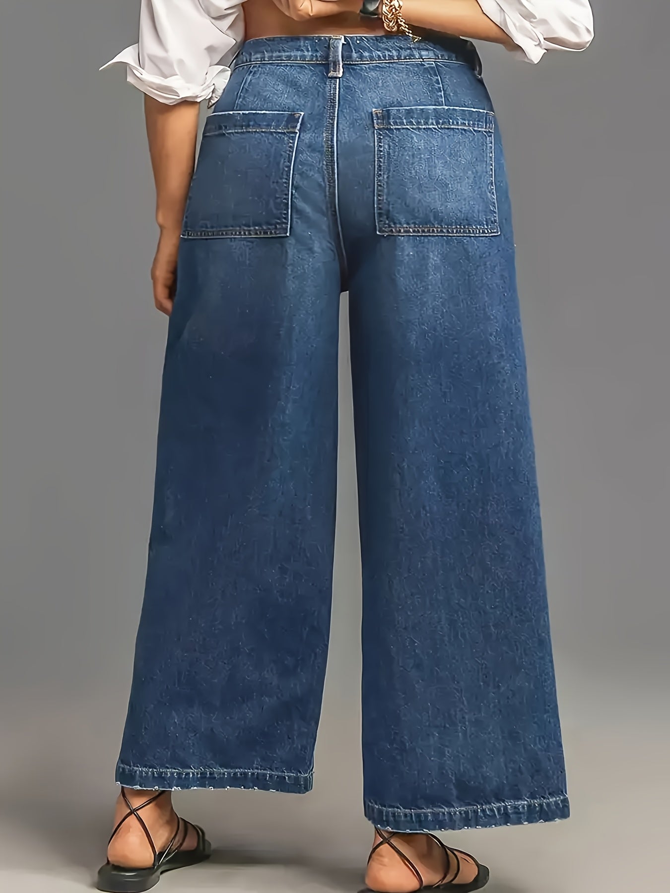 Wide leg high-waisted denim jeans for women in soft blue cotton with slant pockets, loose fit, and mid-rise. Comfortable for all seasons.