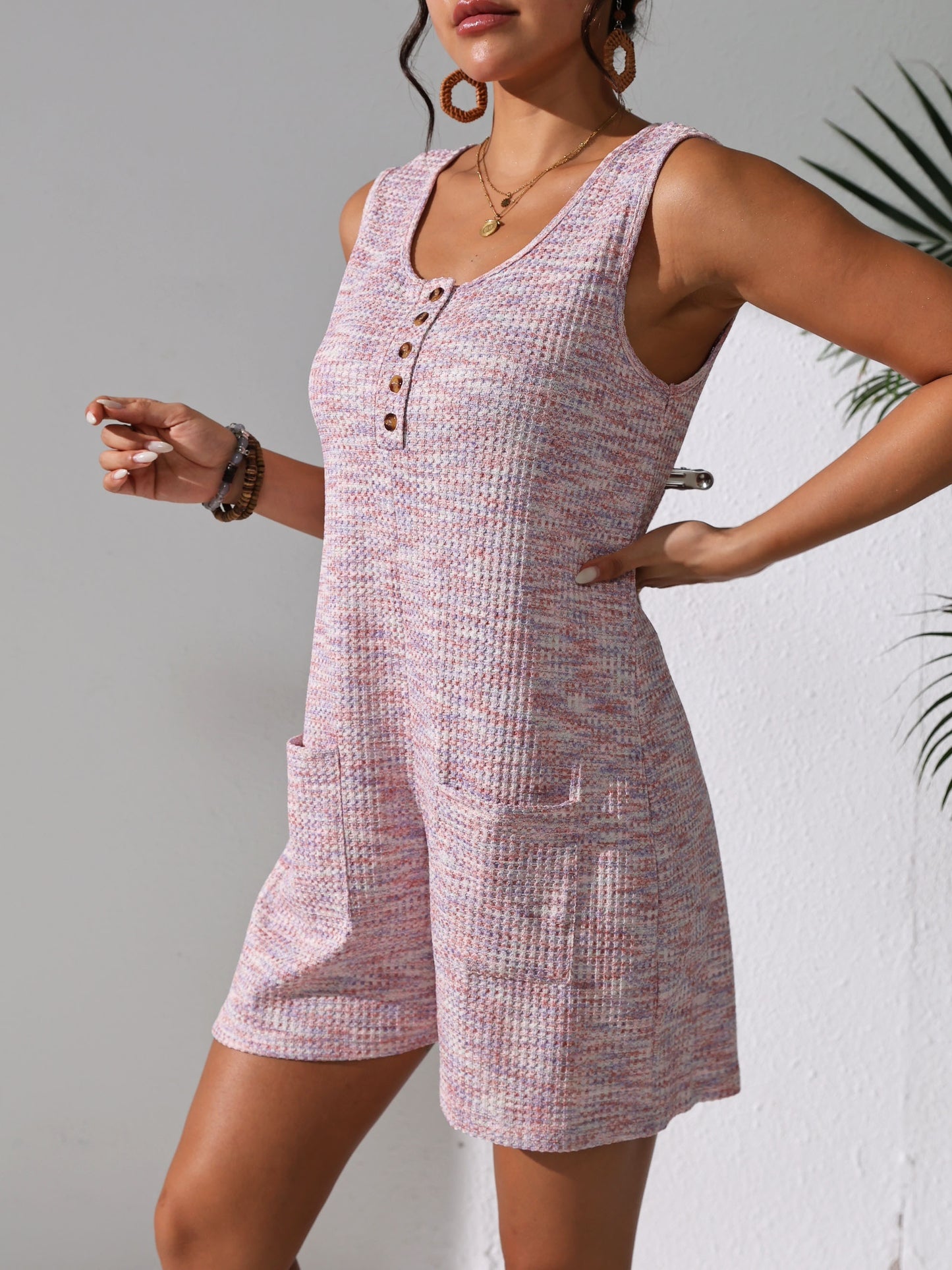 Sleeveless waffle knit romper with pockets for plus-size women in pastel pink. Comfortable and stretchy, perfect for spring/summer.