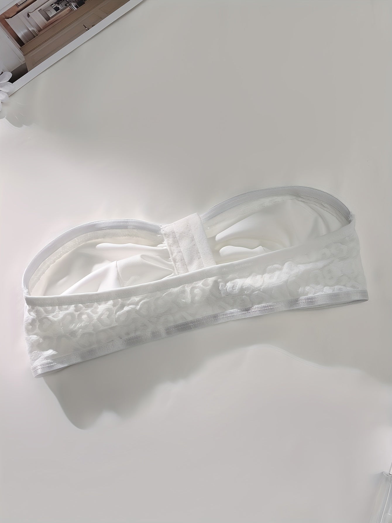 White bandeau bra with front hook closure, ruched design, push-up support, no underwire, soft polyester blend for women.