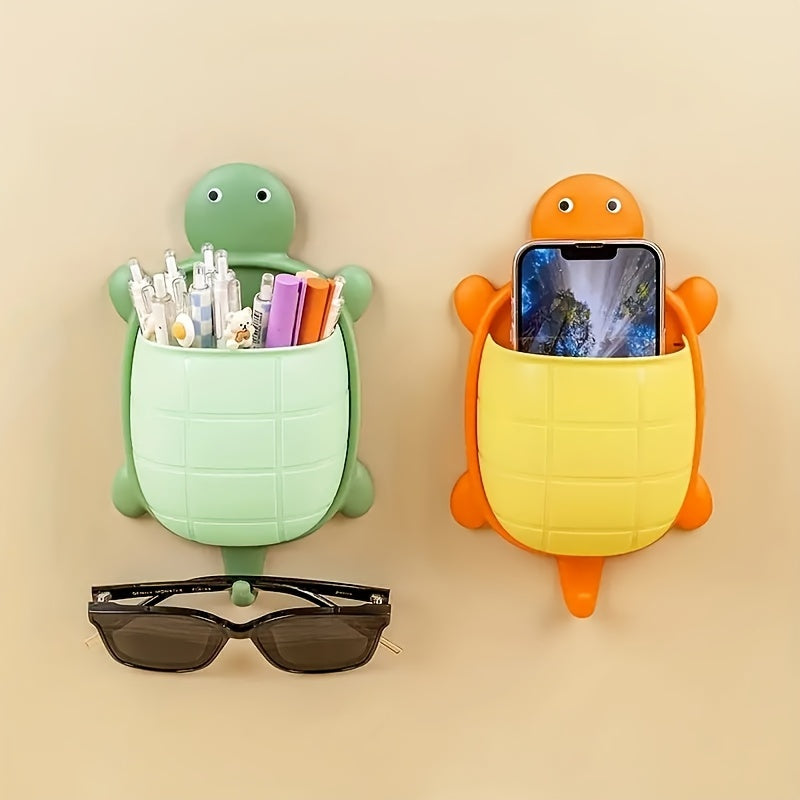 Turtle-shaped wall-mounted remote control holder with self-adhesive storage for home bathroom makeup organization.