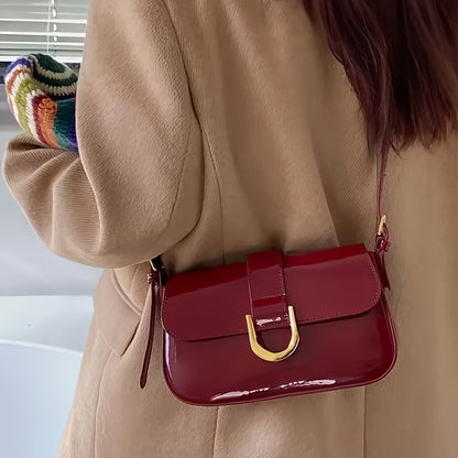 Elegant red baguette bag for women with detachable strap, golden-tone hardware, and glossy finish.