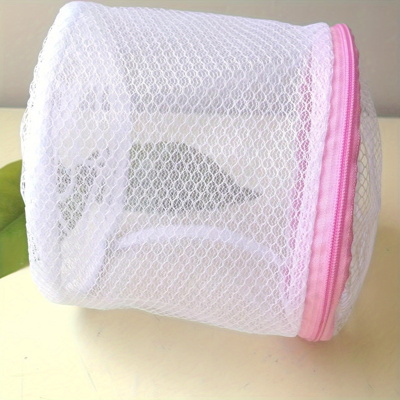 Pink zipper polyester mesh laundry bag, machine wash safe, anti-deformation for delicates and underwear, hexagonal pattern, laundry room accessory.