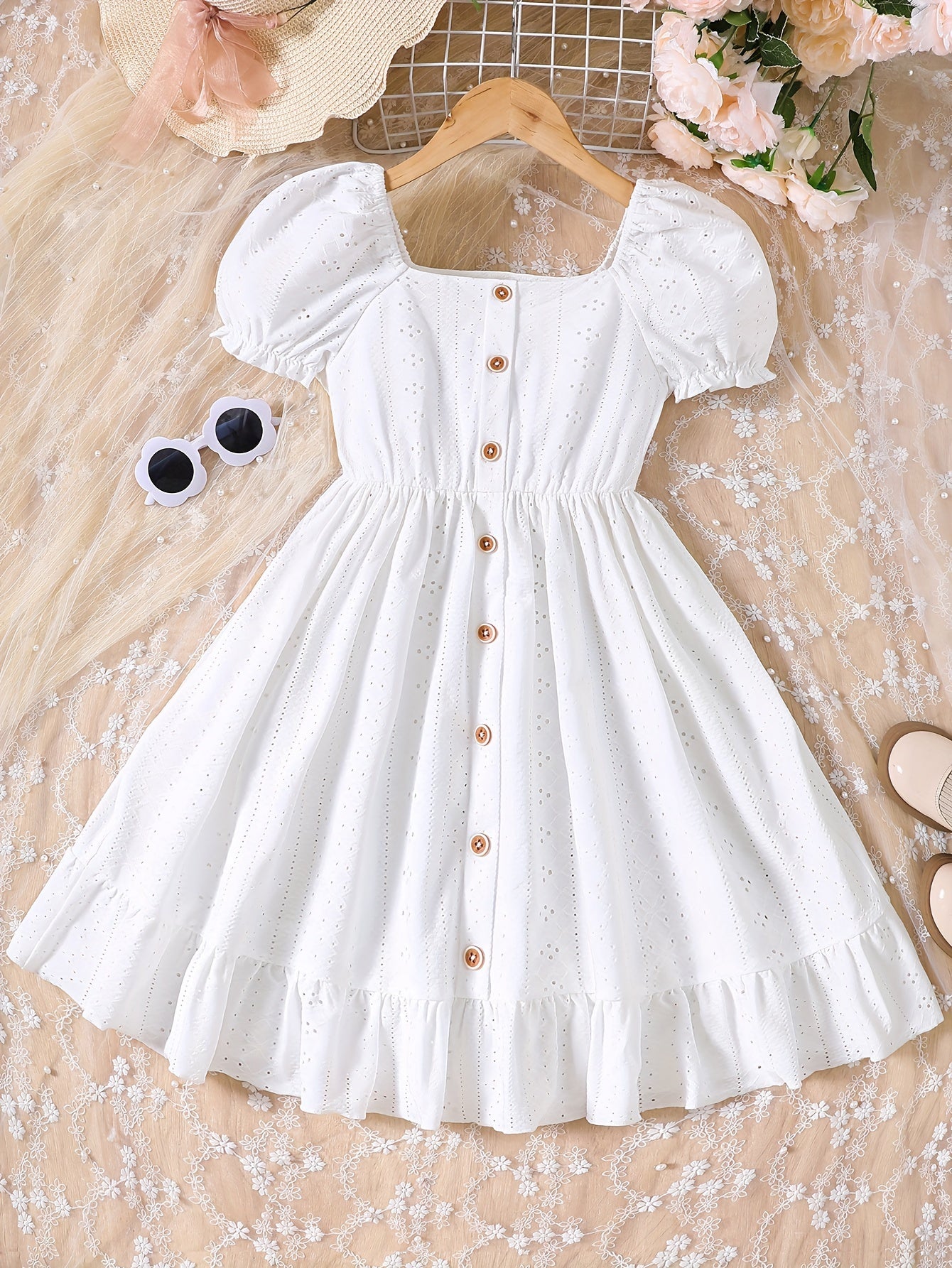 Sweet knit summer dress with charming eyelet jacquard, puff sleeves, and ruffle hem. Casual button-front white dress for young girls.