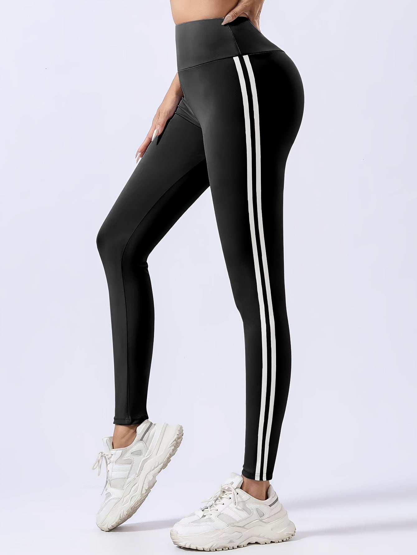 Women's chic black leggings with white side stripes, high-waist design, butt lifting, and tummy control features. Made with quick-dry and breathable fabric for a slimming effect. Machine