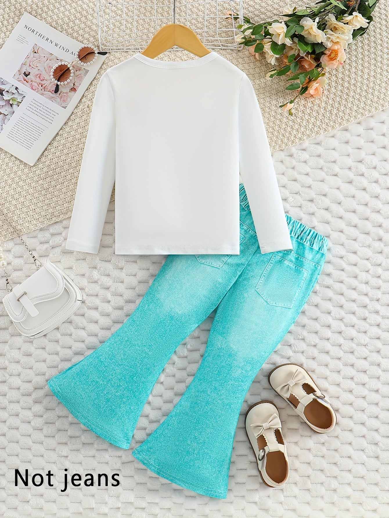 Girls' outfit set includes a long sleeve top with butterfly print and flared faux denim pants with a bow detail. Made of slight stretch knit fabric with an animal pattern, this regular fit