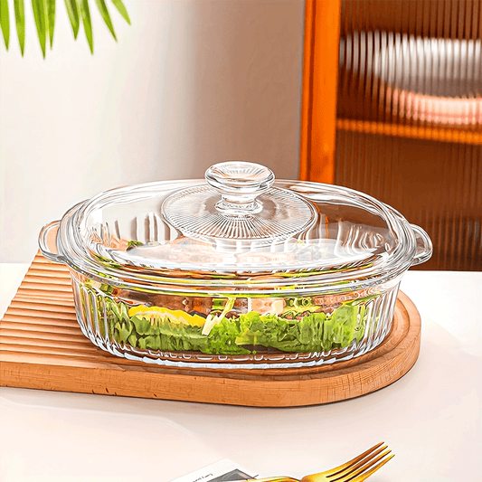 Oval clear glass casserole dish with lid and handles, versatile for microwave, oven, and dishwasher use - ideal for preparing fish, salads, and pasta.