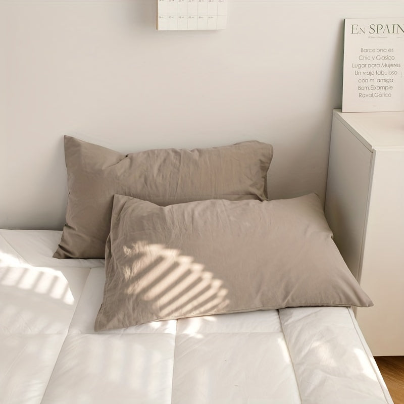 Two polyester pillowcases for bedroom use, featuring a multi-colored solid design.