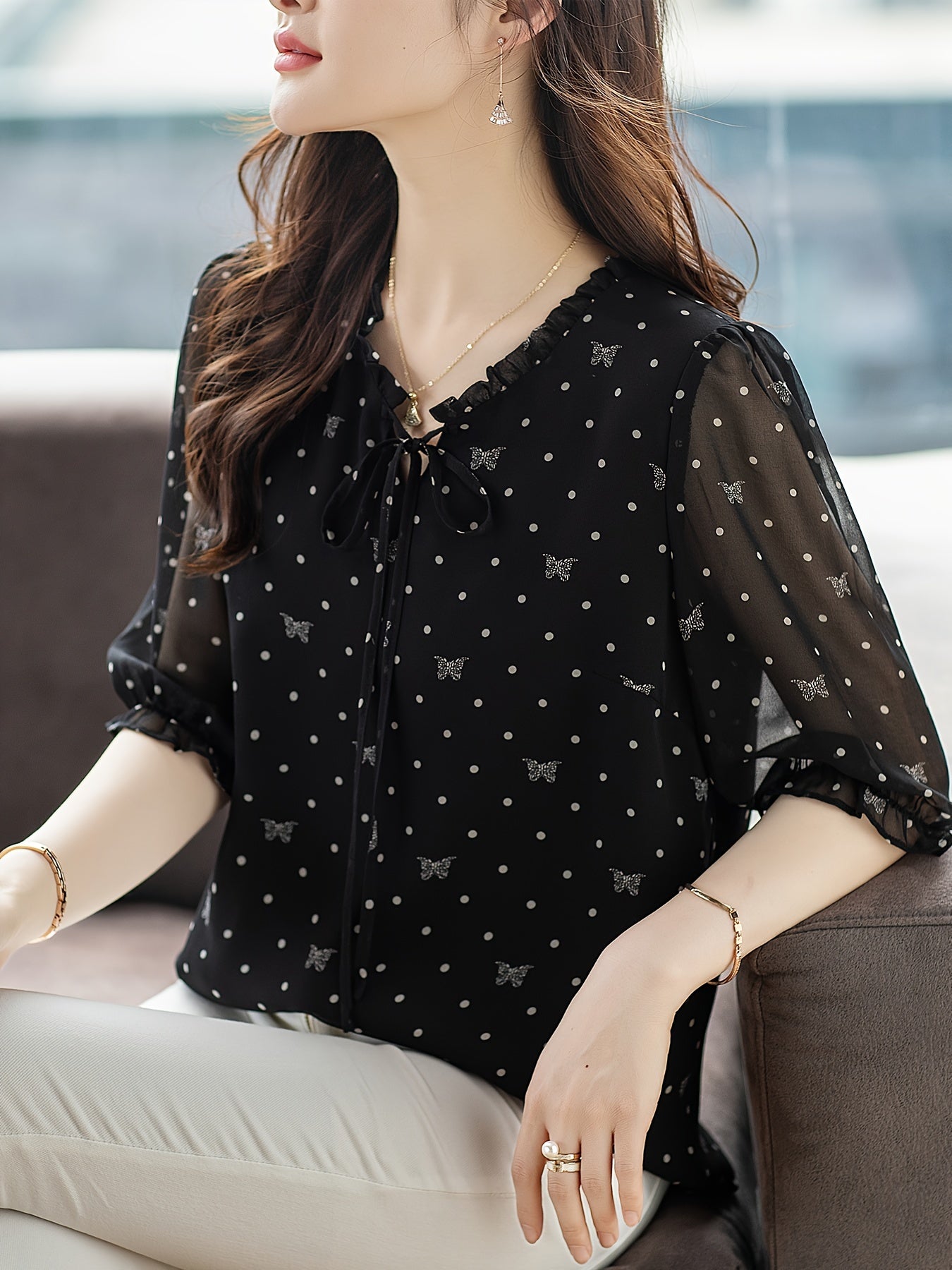 Stylish black floral chiffon blouse with bow tie neckline, sheer sleeves, and non-stretch polyester fabric. Recommended for hand or dry clean only. Ideal for summer 2024.