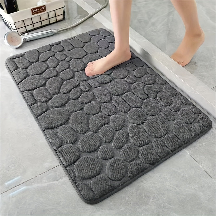 One piece of bath mat with embossed pebble pattern, highly absorbent and non-slip for bathroom use. Suitable for tub, toilet, and floor, made of machine washable polyester material. Dimensions are 59.94x39.88 cm.