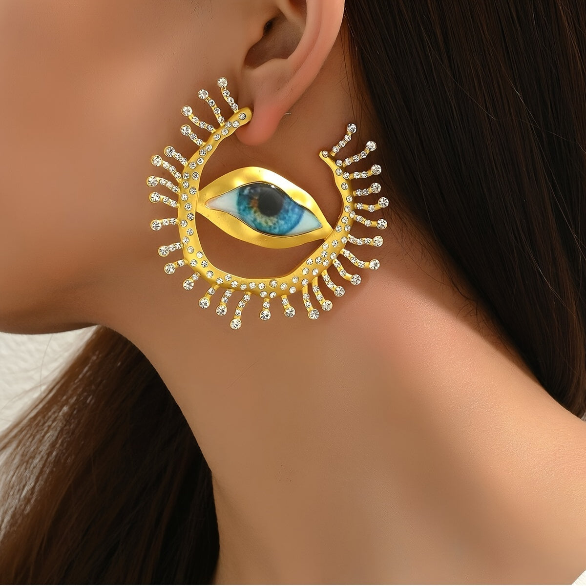 These punk cool style statement earrings feature an exaggerated eye-shaped design with metallic rhinestones. Perfect for parties, vacations, and everyday wear. Add a unique touch to your jewelry collection with this bold pair of dangle earrings.