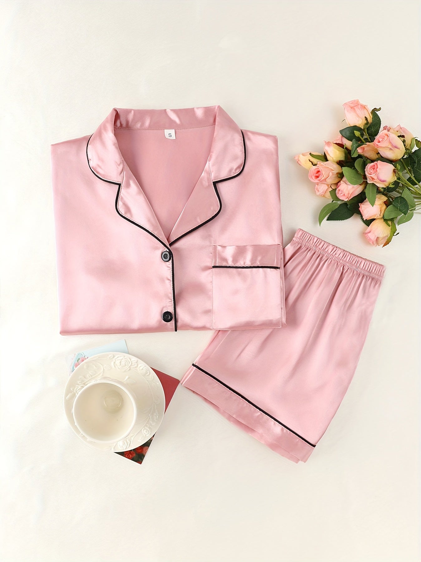 Women's satin pajama set with short-sleeve top and button-up shorts.