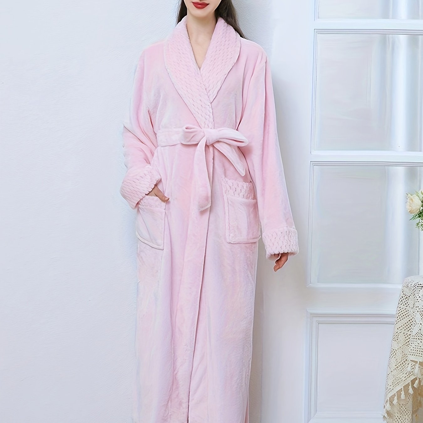 Plush pink flannel bathrobe for women with long sleeves, V-neck, and pockets. Machine washable for winter warmth.