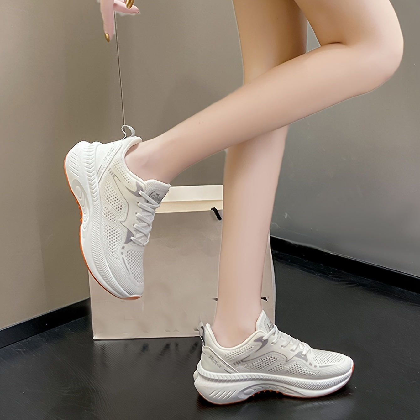 Women's low-top running shoes in white with orange sole, breathable fabric upper, rubber sole, stabilizing support, all-season casual sneakers.