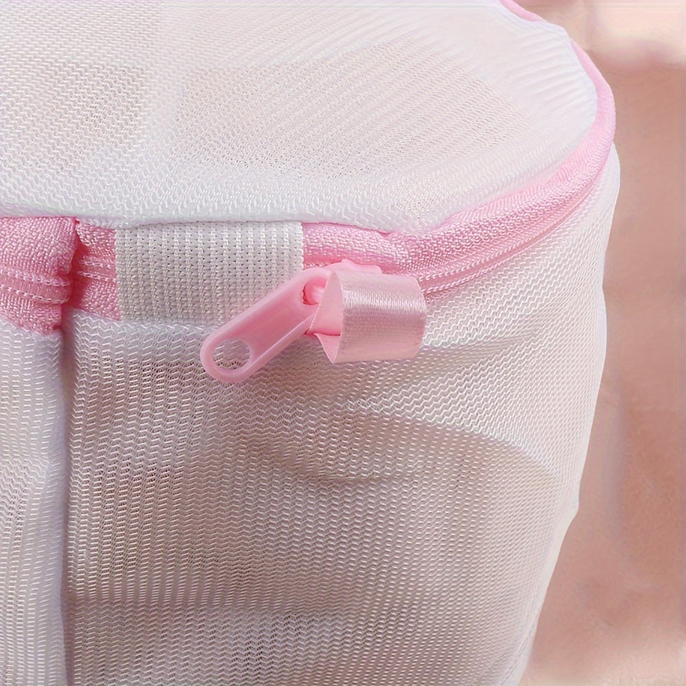 Sturdy polyester mesh laundry bag for delicates with fine grid, pink zipper. Hand washable, prevents deformation in washing machine. Breathable mesh design, laundry room essential.