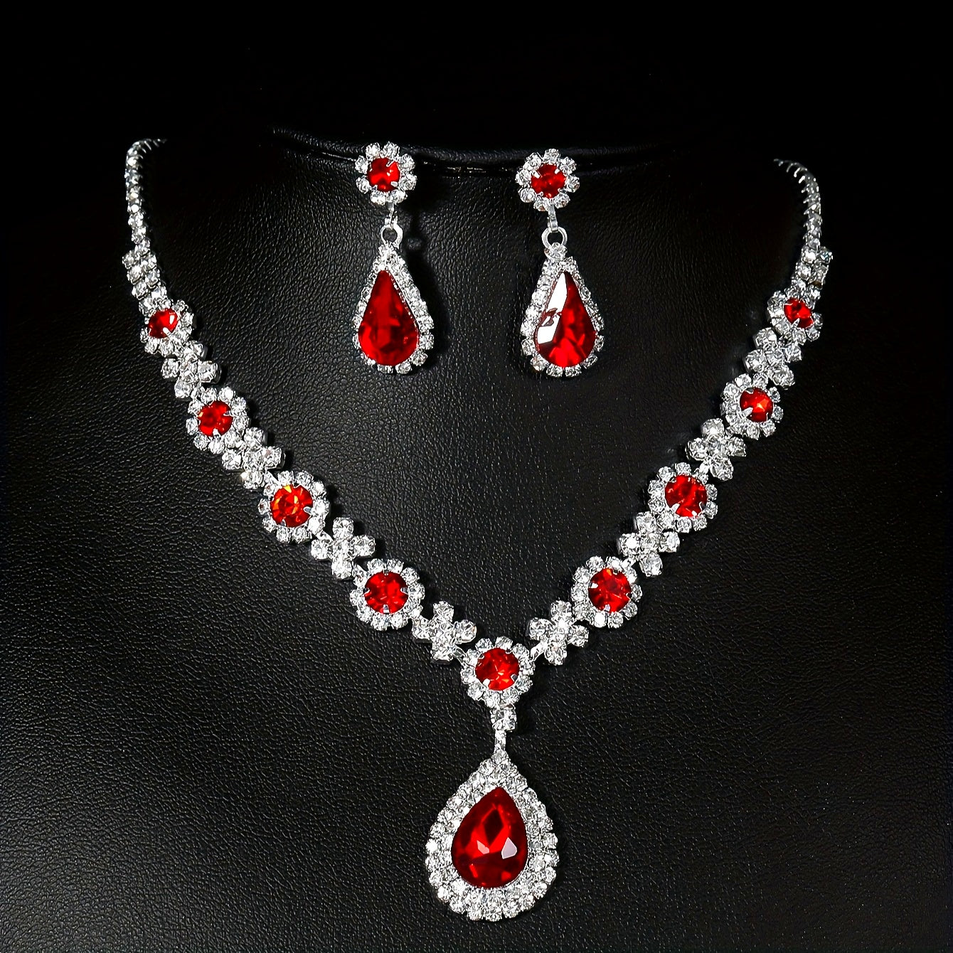 Stylish and opulent silver plated necklace and earrings set adorned with red rhinestone flower detailing and teardrop pendants. This elegant copper fashion jewelry set is designed for women, ideal for parties, banquets, and Valentine's Day. A versatile