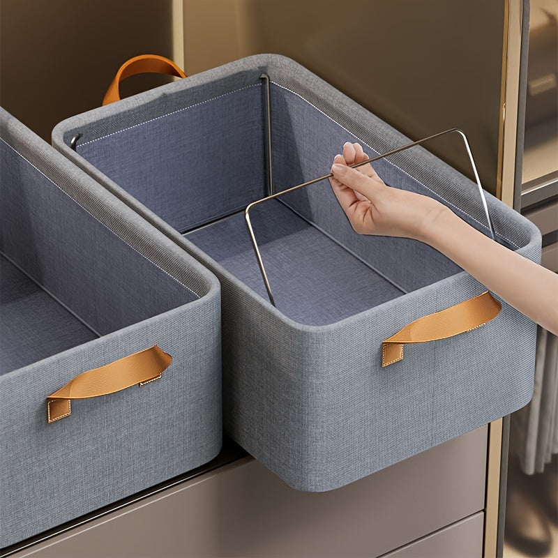 Two folding storage bins featuring metal frames, made of household fabric with handles. These large capacity boxes are perfect for storing clothes or toys in a closet, wardrobe, dorm room, or under the bed, serving as a space-saving organization solution.