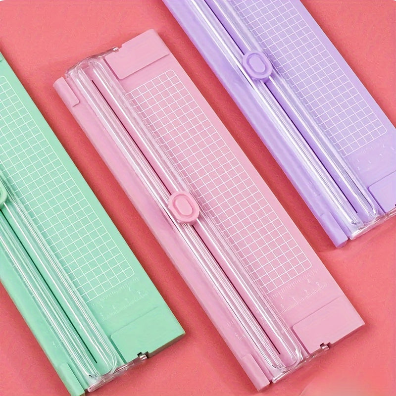 Compact sliding paper cutter for A4 paper, photos, copy paper, and stationery. Dual-direction design with measuring ruler. Available in bright pink, purple, green, blue, and black. Compact