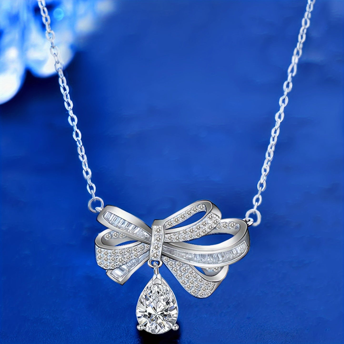 This elegant pendant necklace features 2.0 carats of moissanite in a teardrop tassel bow design, crafted in pure S925 silver. It is a high-end fashion accessory perfect for everyday wear, with its simple and elegant design suitable for parties and as a