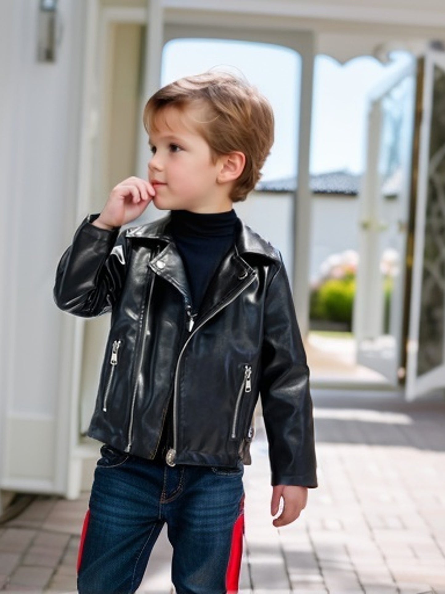 Stylish boys' motorcycle-inspired black jacket with zippered pockets, button closure, and belt detail for spring/fall.