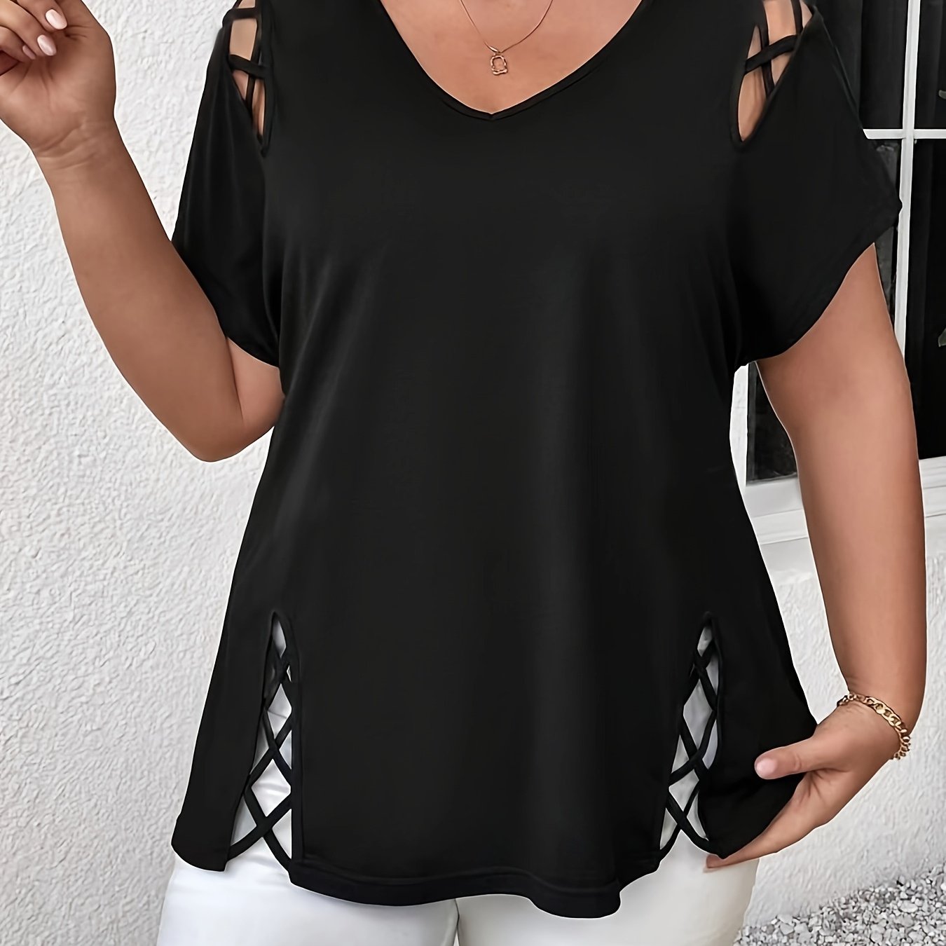 Stylish plus-size women's top with V-neck and crisscross detail, made of medium-stretch fabric, suitable for all seasons.