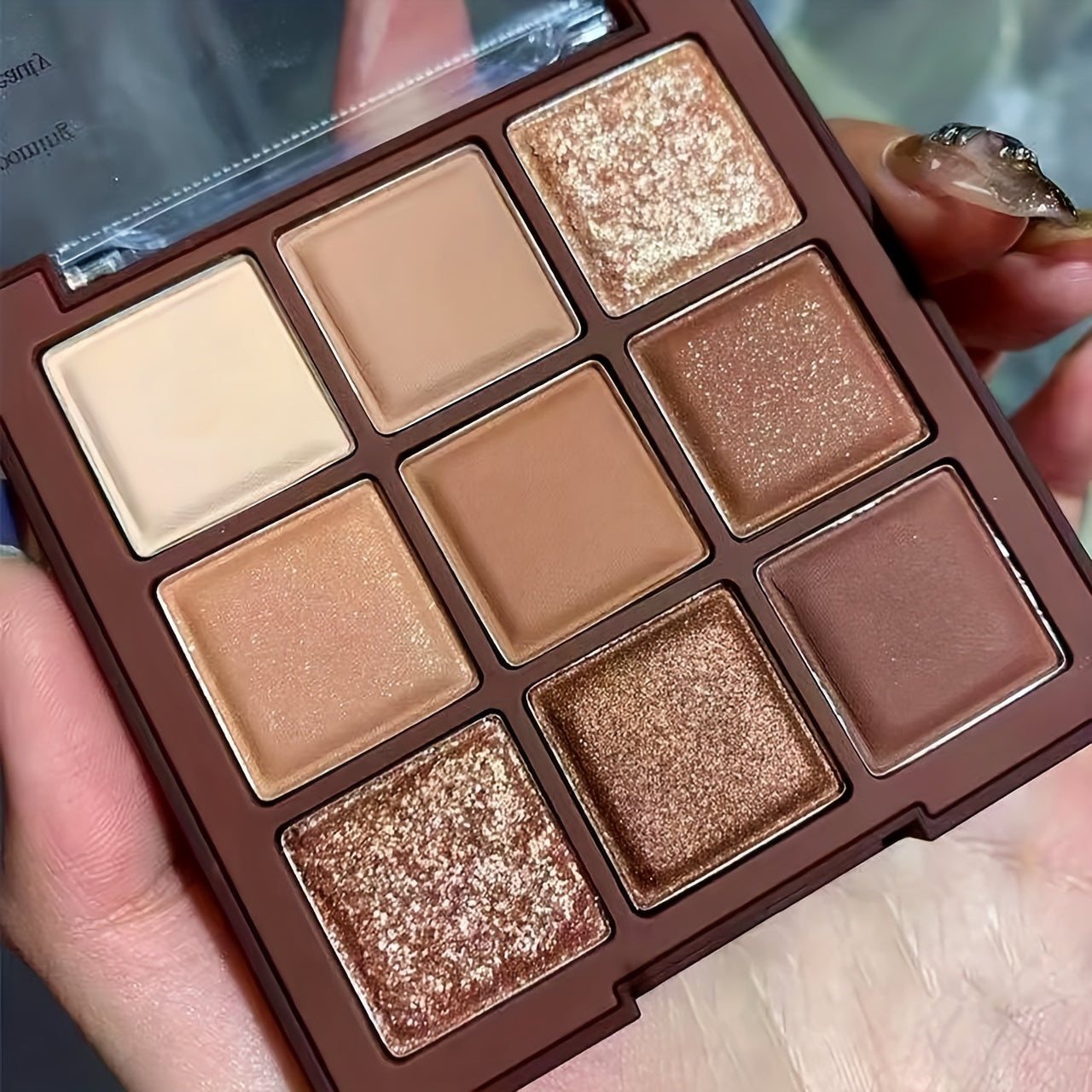 9-color chocolate brown eyeshadow palette with natural matte, shimmer, and glitter pigments. Waterproof, sweat-proof, and professional beauty makeup kit.