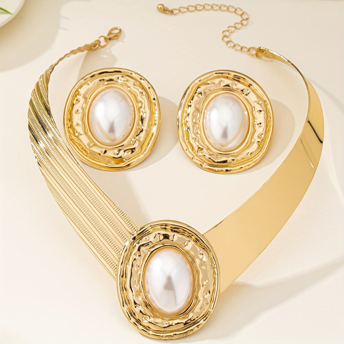 A stylish and modern set of golden pearl earrings and necklace for women, a stunning jewelry set that makes a statement - ideal for giving as a gift on special occasions.