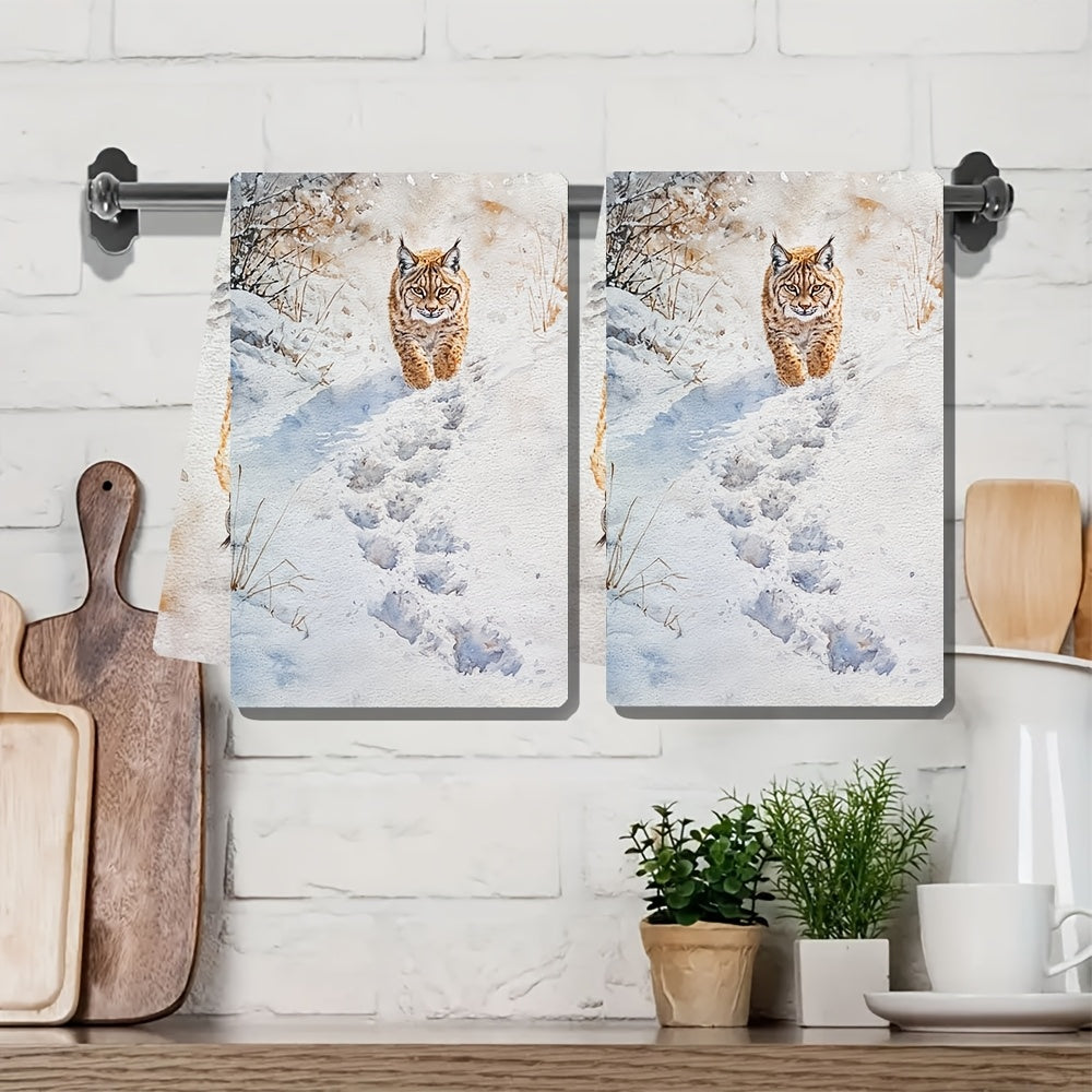 Two pieces of Lynx Snow Footprints kitchen towels, made of super absorbent polyester knit fabric. These towels are machine washable and feature a contemporary coastal style, measuring 40.64x60.96 cm. They are perfect as dish hand towels for holiday decor.